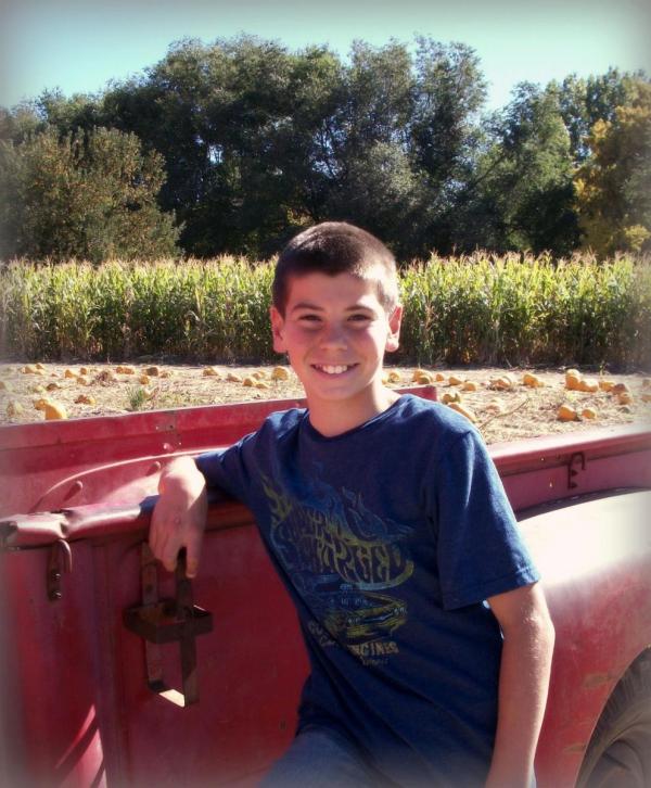 Tim standing in front of a truck in a field of pumpkins